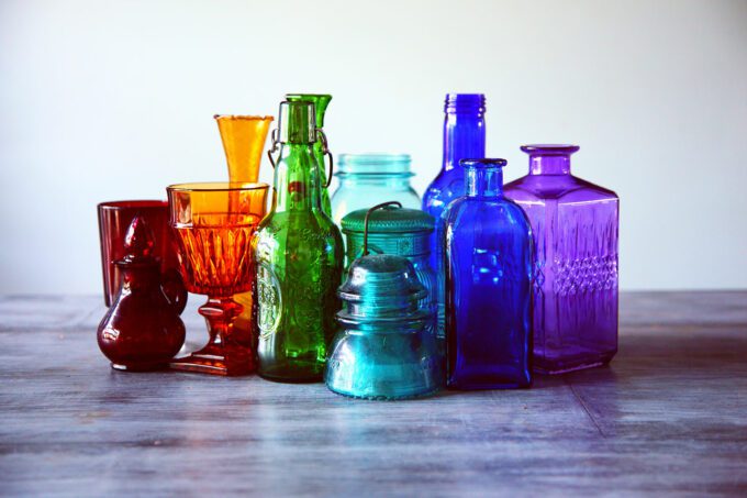 a group of colored glass jars and containers
