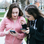 two high school girls using a phone