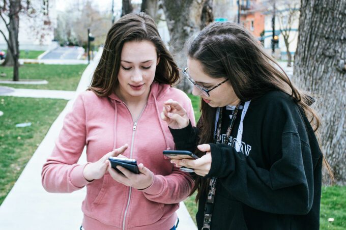 two high school girls using a phone