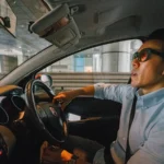 asian man in the driver seat of a car waiting in traffic