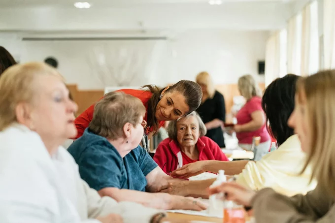 a group of older adult women sitting at a table at an assisted living commnity