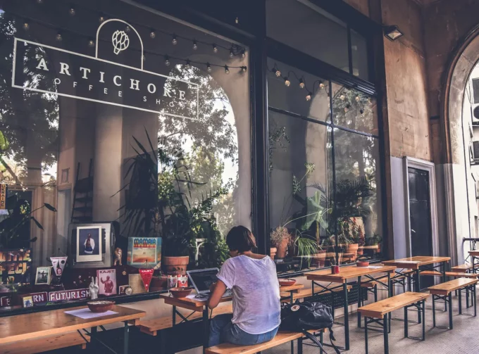 a white woman working on a computer at a coffee cafe