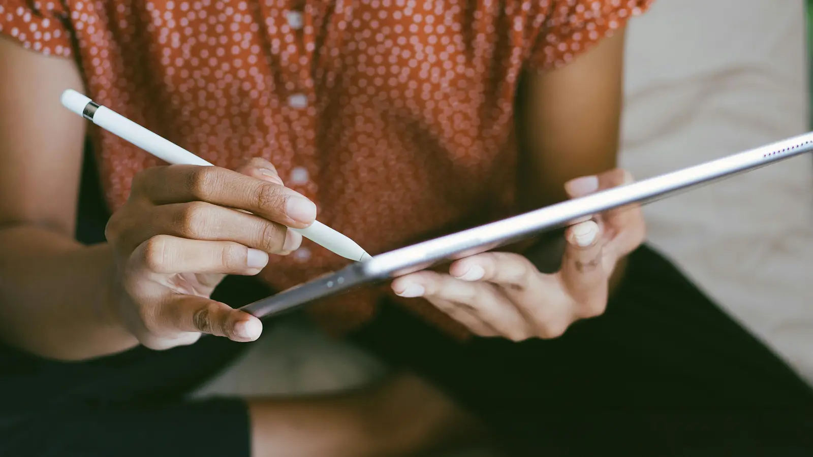 a black woman using a stylus to draw on an iPad screen