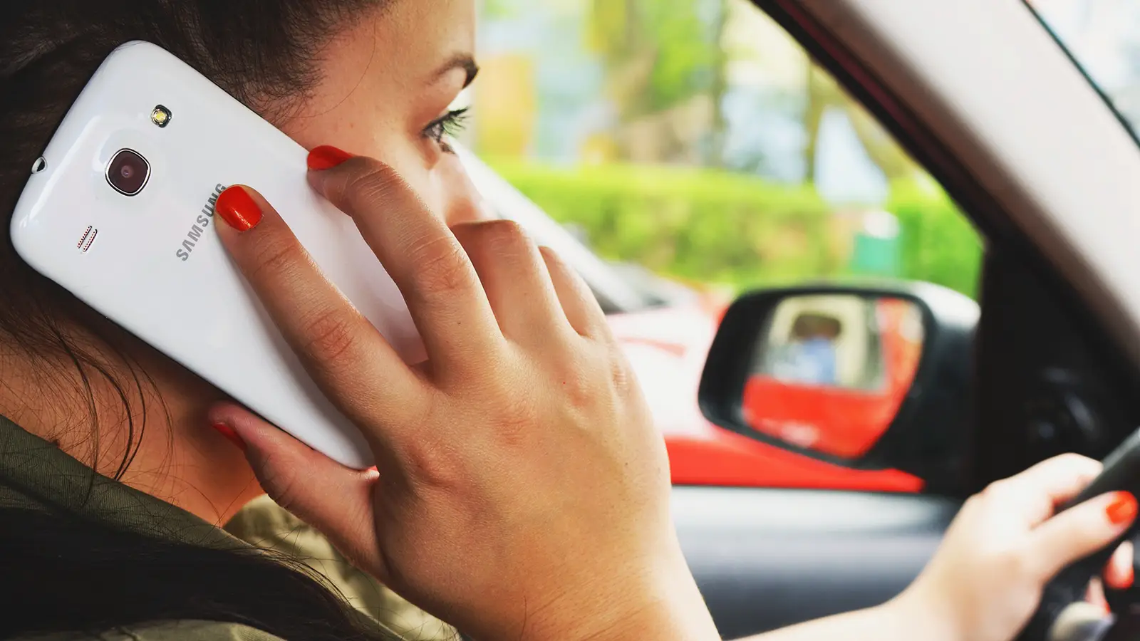 woman driving while talking on phone