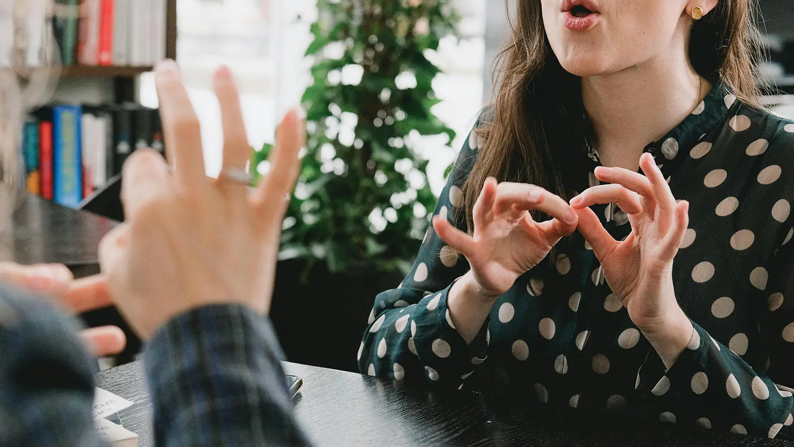 two white women using sign language to have a conversation with one another