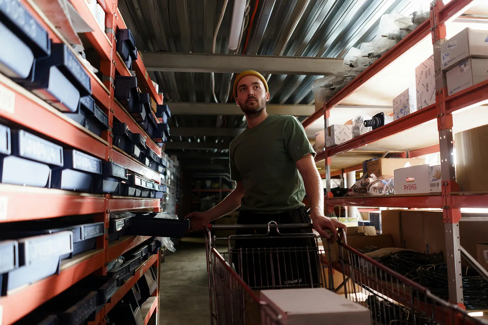 a man working in a warehouse loading items onto a cart