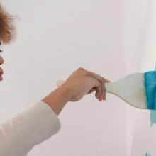 a black woman using a brush to paint a painting