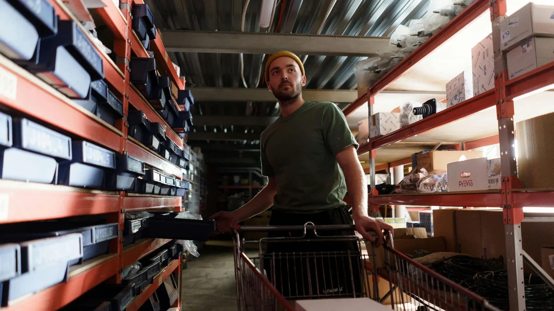 a man working in a warehouse loading items onto a cart