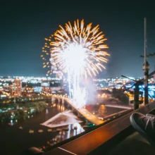 man viewing fireworks in a city from the roof