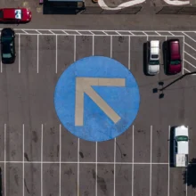 a top down view of a parking lot with parking space lines and directional arrows