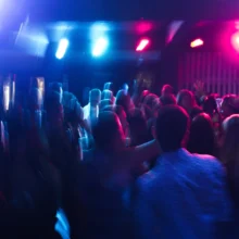 people dancing at a concert with bumping beats and flashing lights