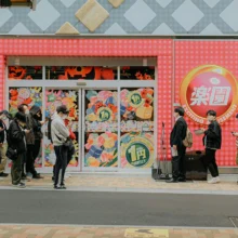 a line of people waiting in front of a store for it to open