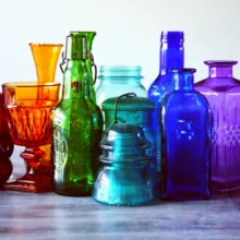 a group of colored glass jars and containers