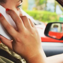 a white teenage woman driving while talking on phone