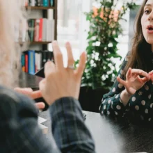 two white women using sign language to have a conversation with one another