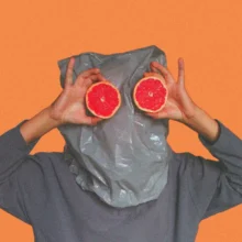 person with bag over head and grapefruits for eyes