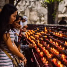 women lighting candles at a religious sactuary
