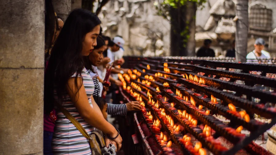 women lighting candles at a religious sactuary