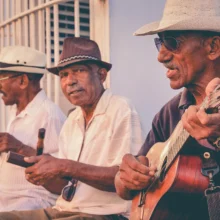 three older adults playing guitars