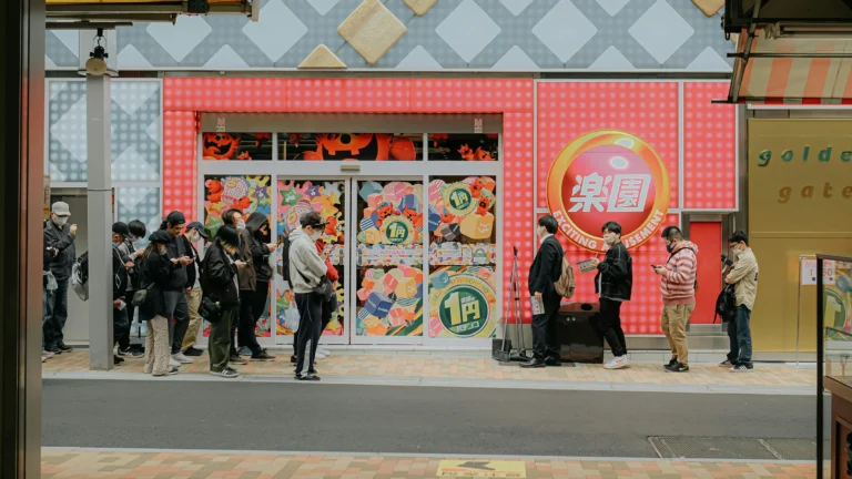 a line of people waiting in front of a store for it to open