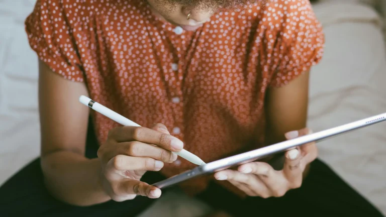 a black woman using a stylus to draw on an iPad screen