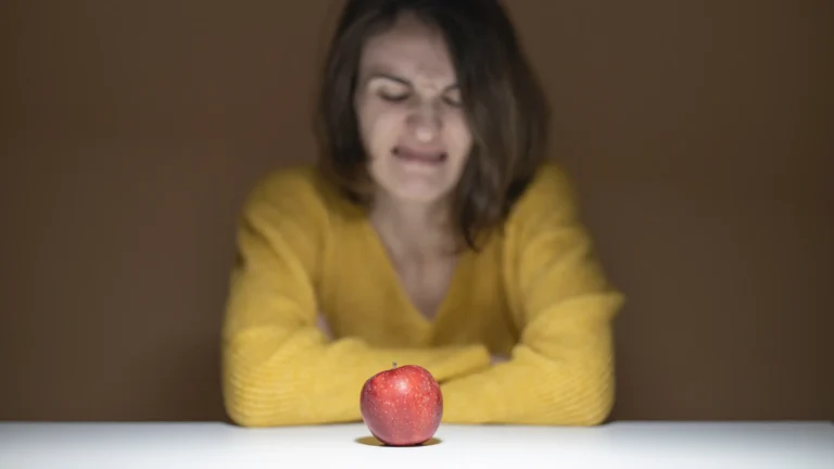 woman disgusted looking at apple