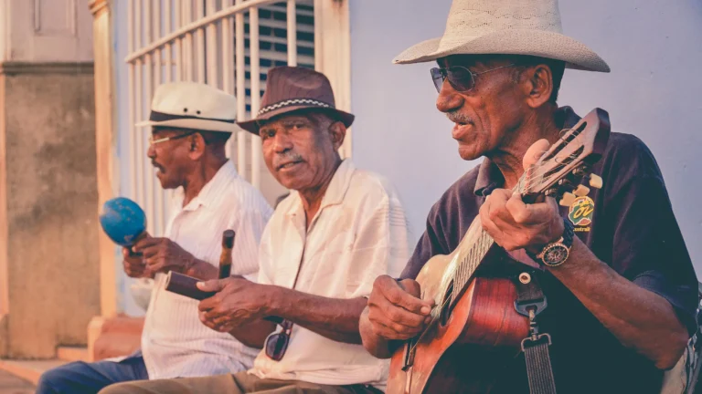 three older adults playing guitars